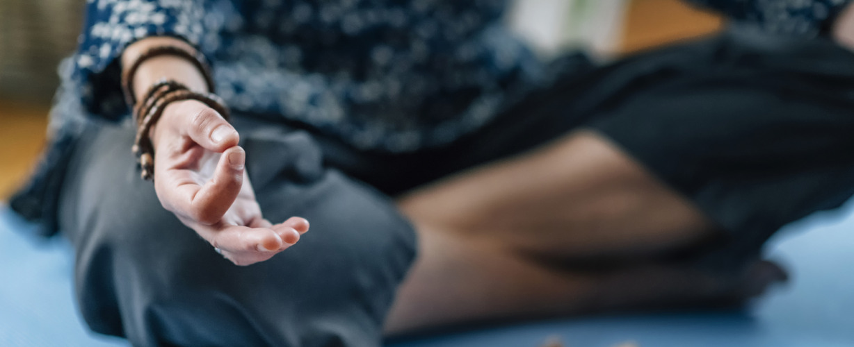 Low Section Of Woman Meditating At Home